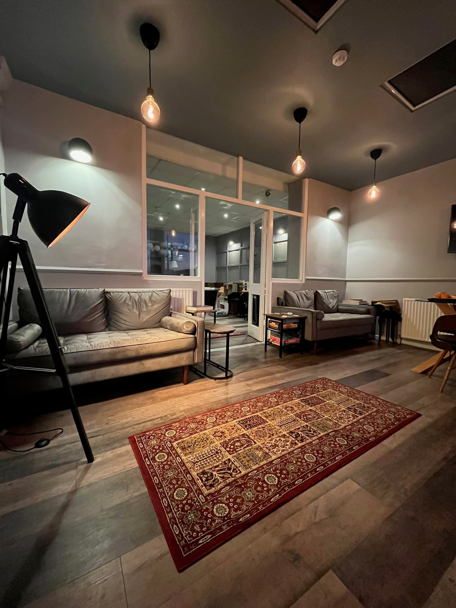 Guest lounge with sofas, warm lighting and a patterned rug